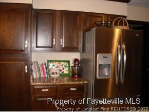 6823 Uppingham Road Fayetteville, NC 28306 - Photo 12 of 18 a kitchen with metallic refrigerator and cabinets