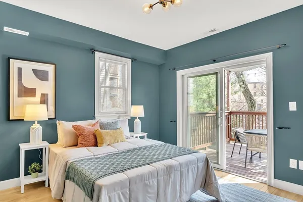 a bedroom with a balcony a bed and a window