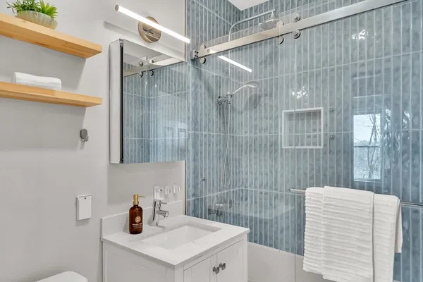 a bathroom with a sink a toilet and shower