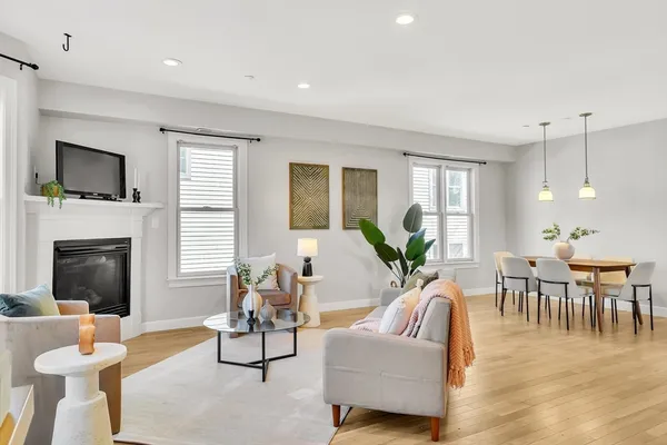a living room with furniture a flat screen tv and a fireplace