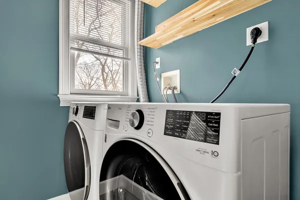 a view of washer and dryer with bathroom in the background