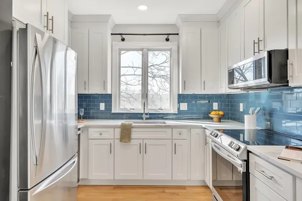 a kitchen with cabinets appliances a sink and a window