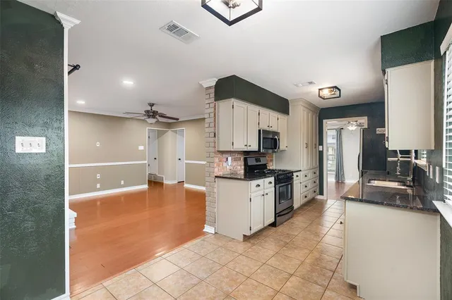 a large kitchen with cabinets and a view of living room