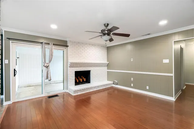 a view of an empty room with a fireplace and a window