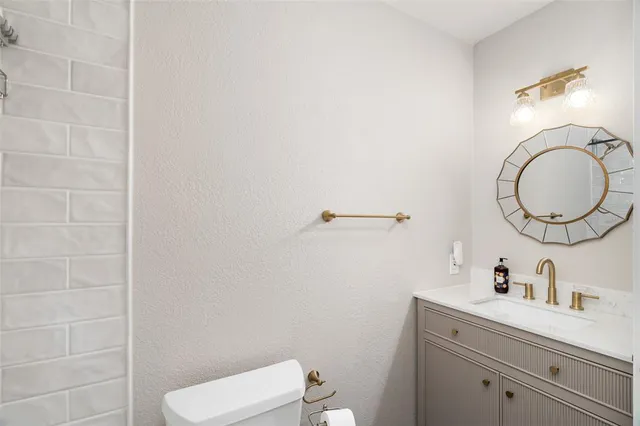 a bathroom with a sink a toilet and a mirror