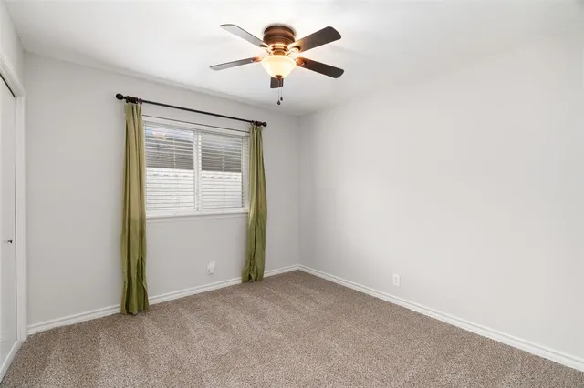 an empty room with closet and a chandelier fan