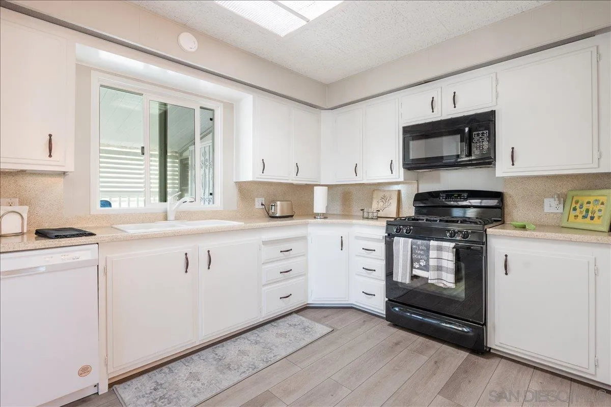 90 Blue Sky Lane Oceanside, CA 92056 - Photo 12 of 26 a kitchen with stainless steel appliances granite countertop a stove a sink and a microwave