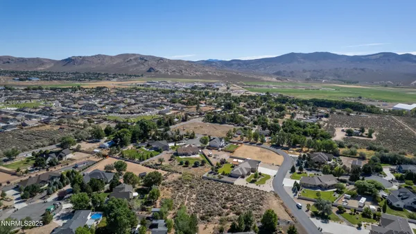 a view of a dry yard with mountains in the background
