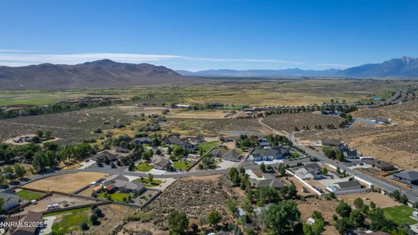 an aerial view of ocean and residential houses with outdoor space
