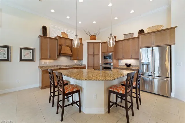 a kitchen with stainless steel appliances granite countertop a refrigerator and a stove top oven with wooden floor