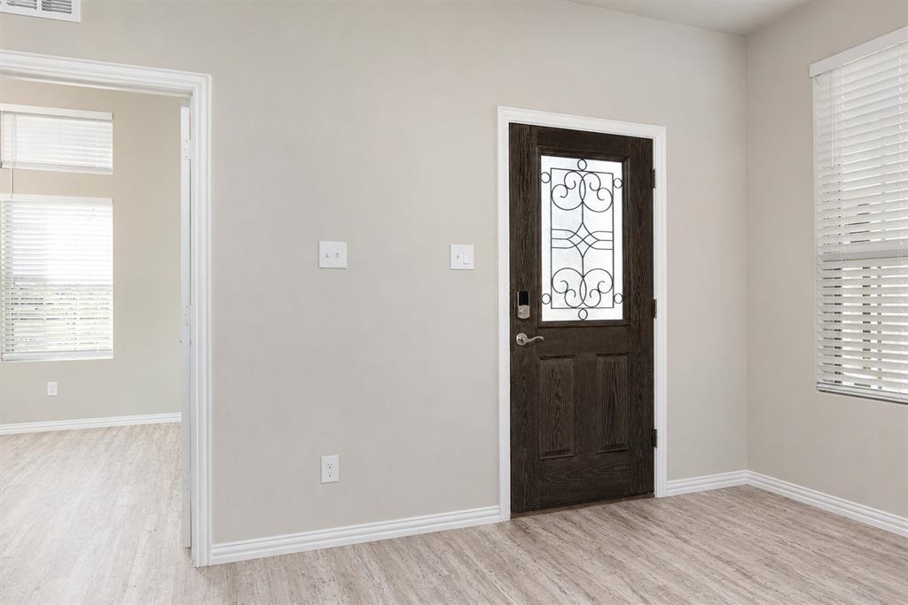3704 Banton Street Rowlett, TX 75089 - Photo 3 of 16 Entryway featuring a dark wood-finish door with decorative glass inlay, light wood-finish flooring, and crisp white baseboards