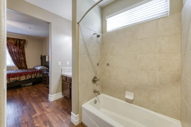 a bathroom with a tub shower and sink
