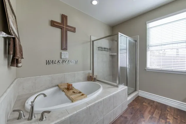 a bathroom with a tub a sink and a window