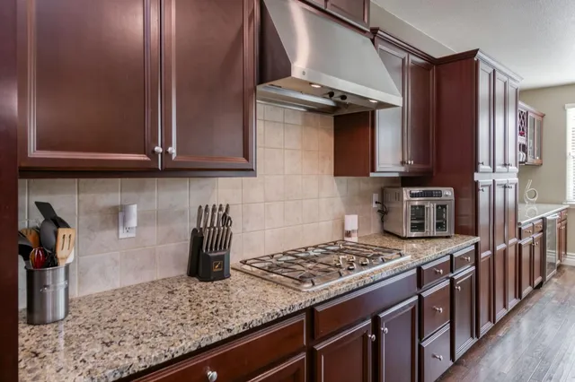 a kitchen with stainless steel appliances granite countertop a stove and a sink