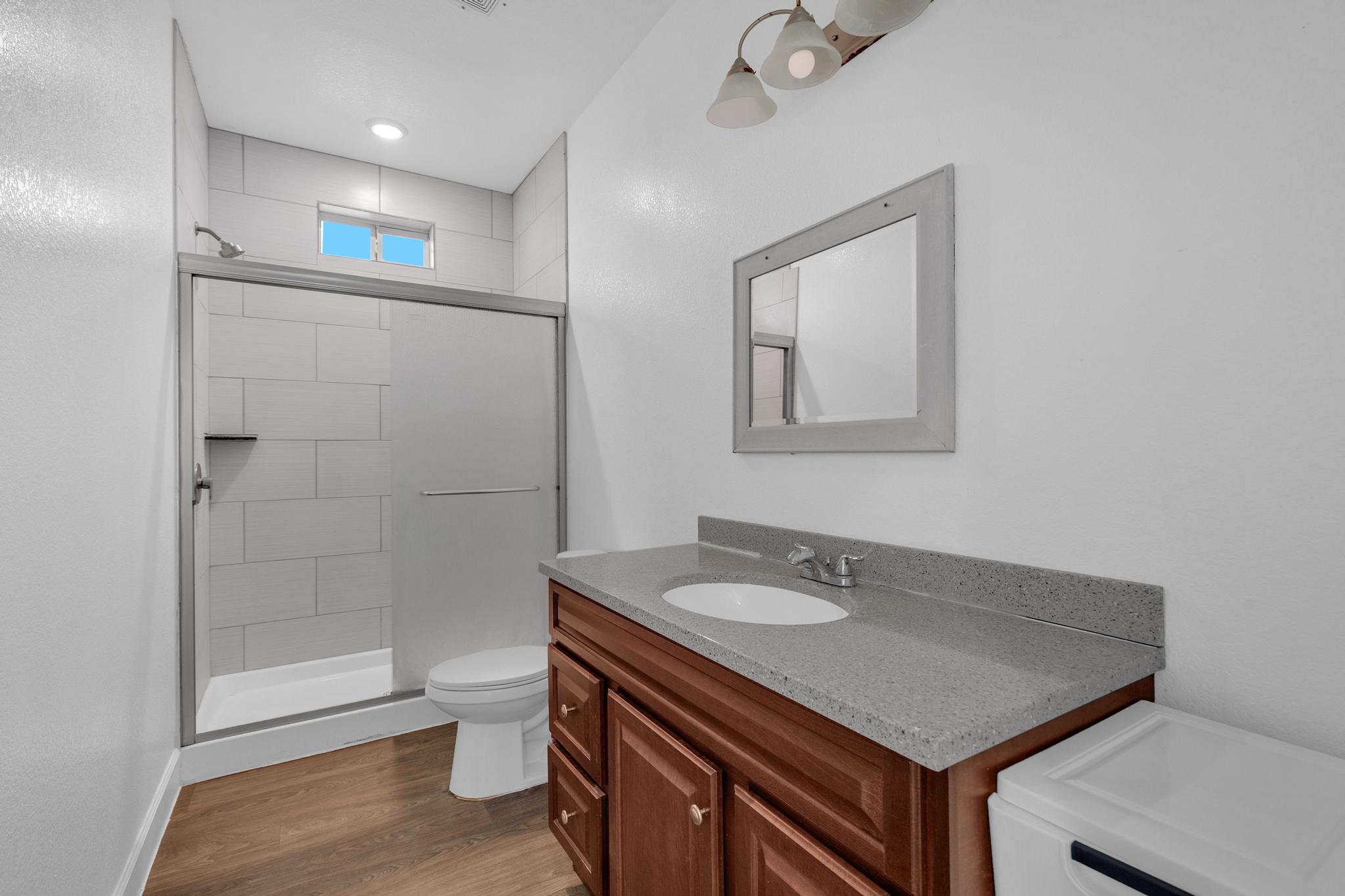 114 Crepe Myrtle Parkway Elgin, TX 78621 - Photo 12 of 40 Unit A - Full bath featuring vanity, a stall shower, and dark wood-type flooring