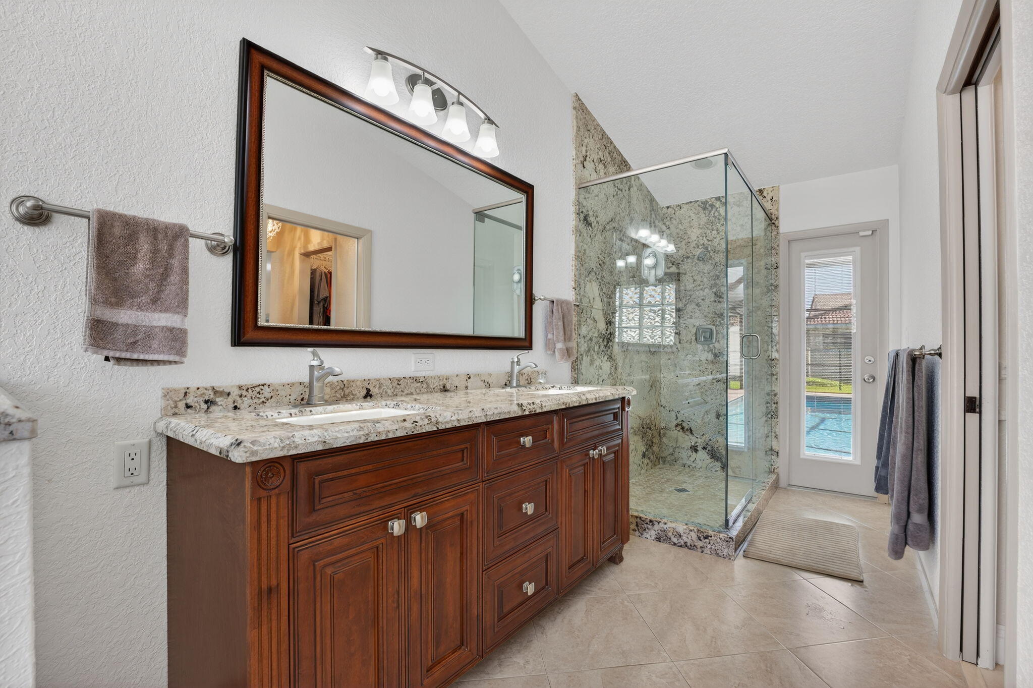 5111 Northwest 85th Road Coral Springs, FL 33067 - Photo 26 of 47 a spacious bathroom with a granite countertop sink mirror and shower