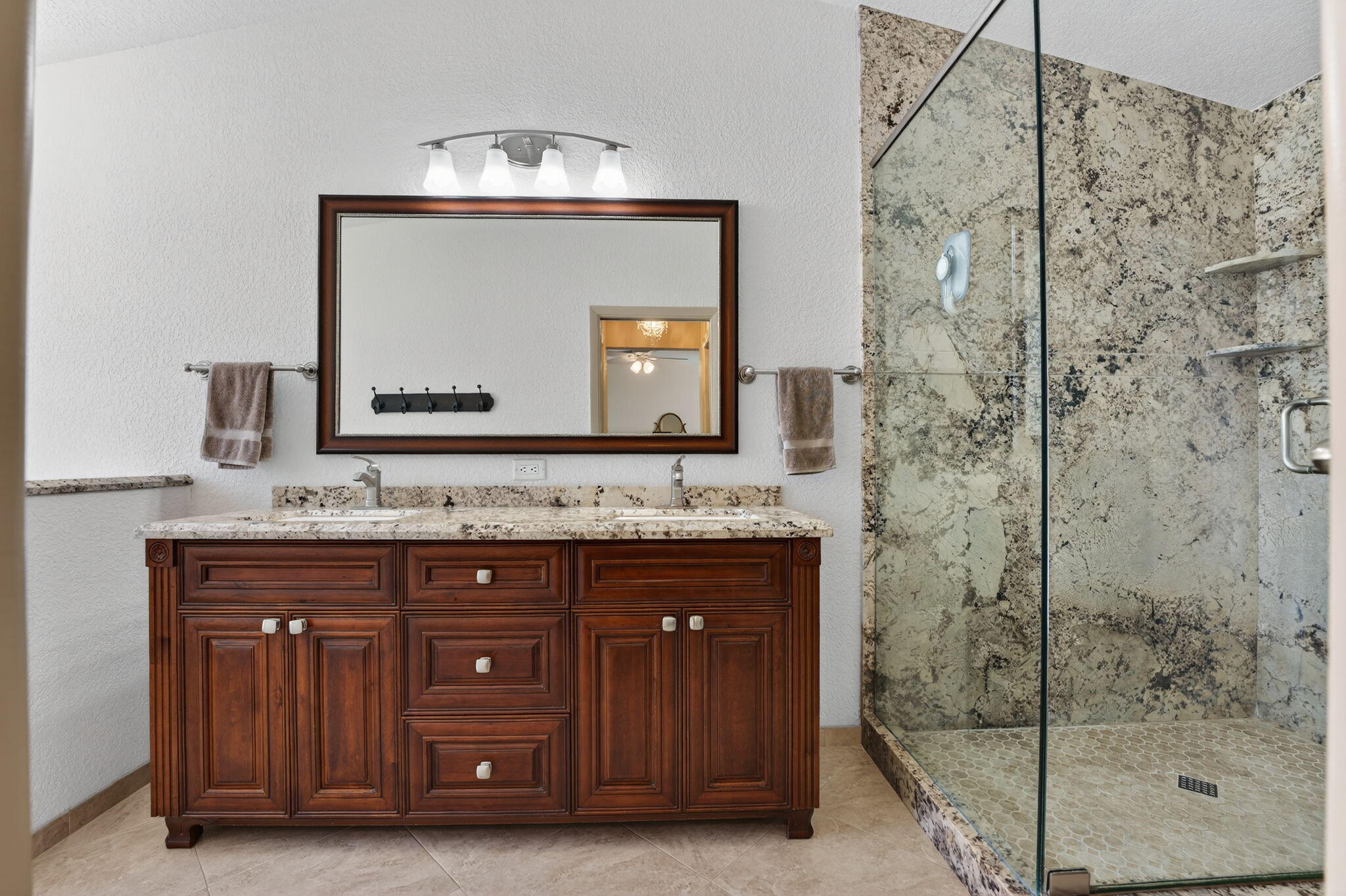 5111 Northwest 85th Road Coral Springs, FL 33067 - Photo 27 of 47 a bathroom with a granite countertop sink a mirror and shower