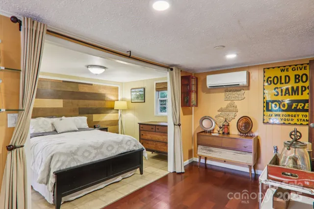 a bedroom with a bed and wooden floor