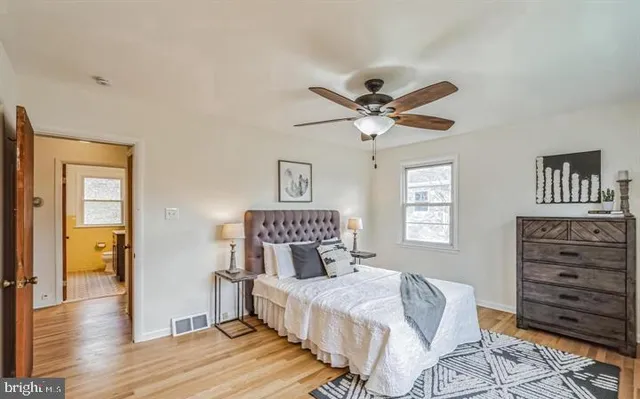a bedroom with a bed chandelier and a window