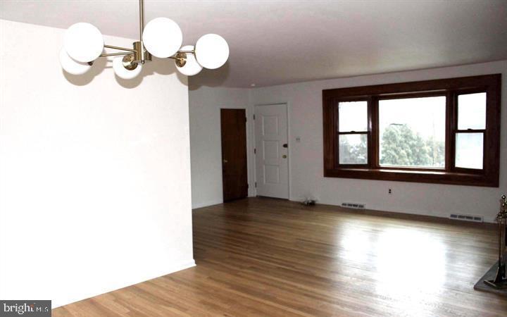 645 Glendale Road Havertown, PA 19083 - Photo 2 of 22 a view of an empty room with wooden floor and a window