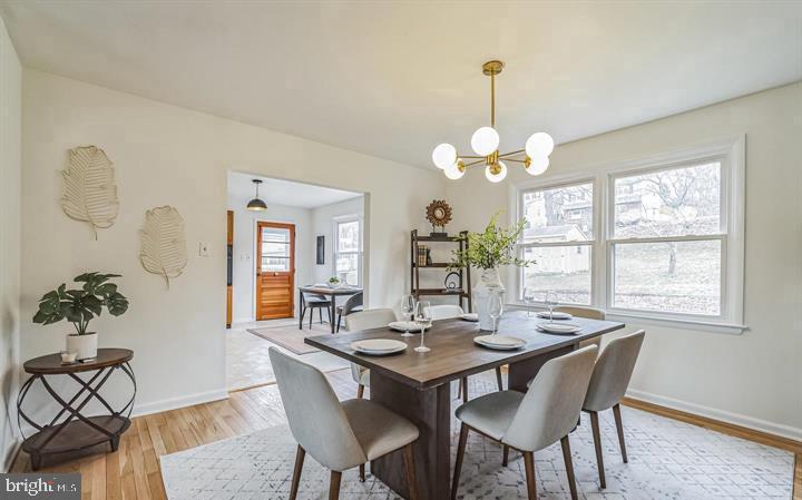 645 Glendale Road Havertown, PA 19083 - Photo 6 of 22 a dining room with wooden floor a chandelier a wooden table and chairs