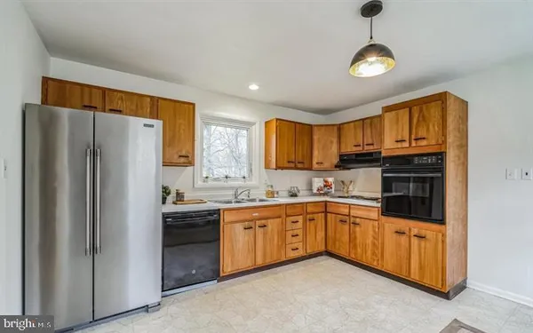 a kitchen with stainless steel appliances granite countertop a refrigerator and a stove top oven