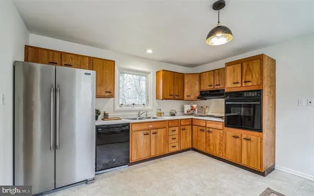 a kitchen with stainless steel appliances granite countertop a refrigerator and a stove top oven