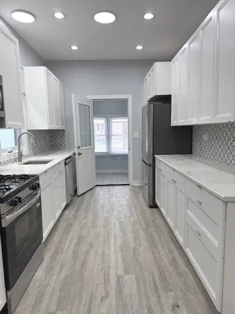 a kitchen with granite countertop a refrigerator stove and sink