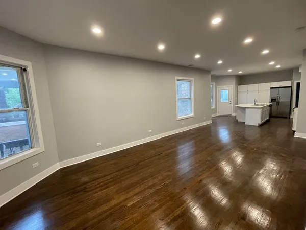 a view of empty room with wooden floor and window