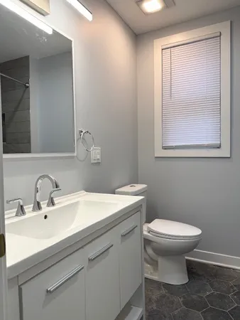 a bathroom with a sink toilet and a mirror