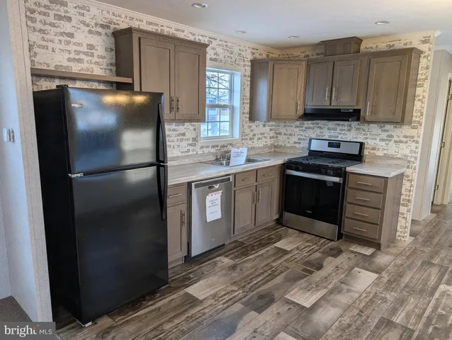 a kitchen with stainless steel appliances granite countertop a refrigerator stove and sink
