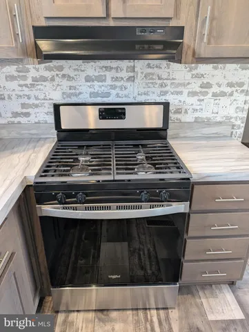a stove top oven sitting inside of a kitchen