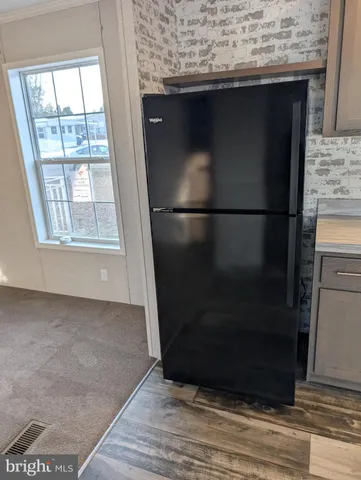 a view of a refrigerator in kitchen and wooden floor