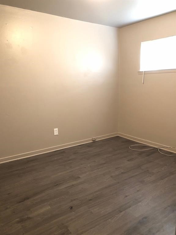 6815 Beachwood Street, Unit 3 Houston, TX 77021 - Photo 4 of 16 an empty room with wooden floor and windows