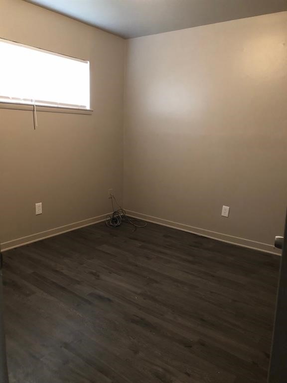 6815 Beachwood Street, Unit 3 Houston, TX 77021 - Photo 5 of 16 an empty room with wooden floor and windows