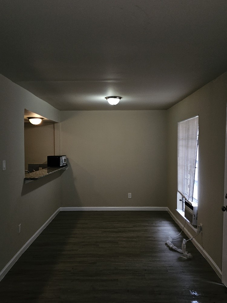 6815 Beachwood Street, Unit 3 Houston, TX 77021 - Photo 9 of 16 a view of an empty room with wooden floor and a window