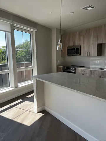 a large kitchen with kitchen island a large window and a sink