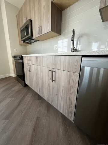 a kitchen with a sink a microwave a refrigerator and cabinets