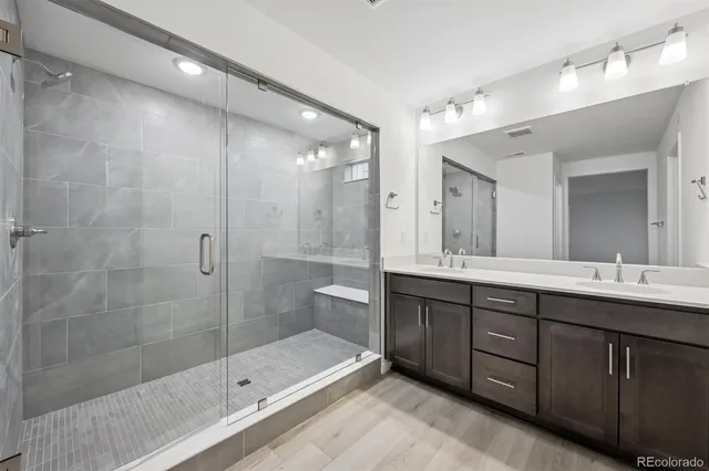 a bathroom with a double vanity sink mirror double and shower