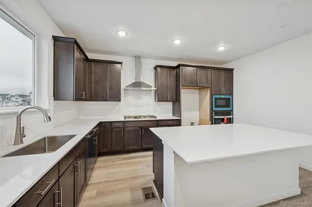 a kitchen with stainless steel appliances a sink stove and refrigerator