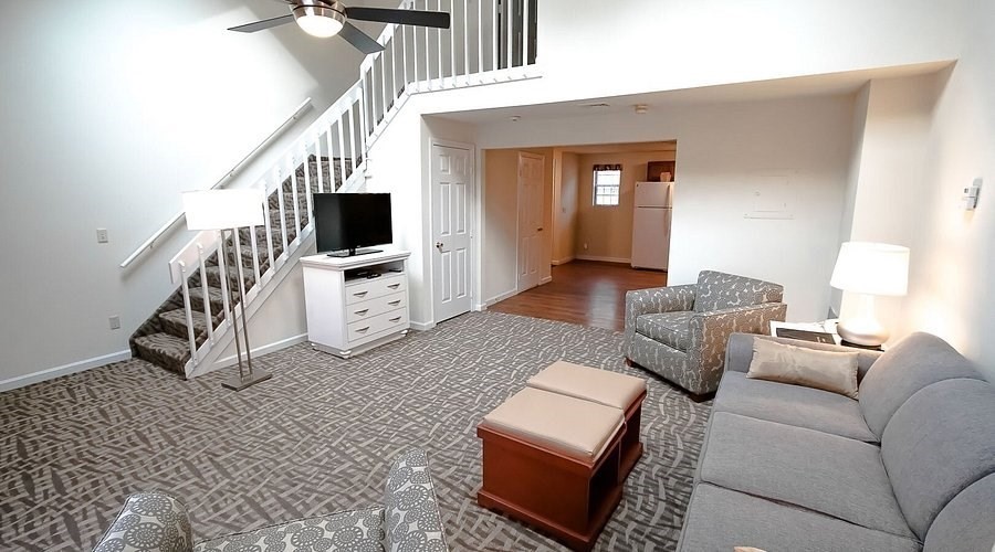 141 Great Neck Road South, Unit 203 Mashpee, MA 02649 - Photo 2 of 16 a living room with furniture and a flat screen tv