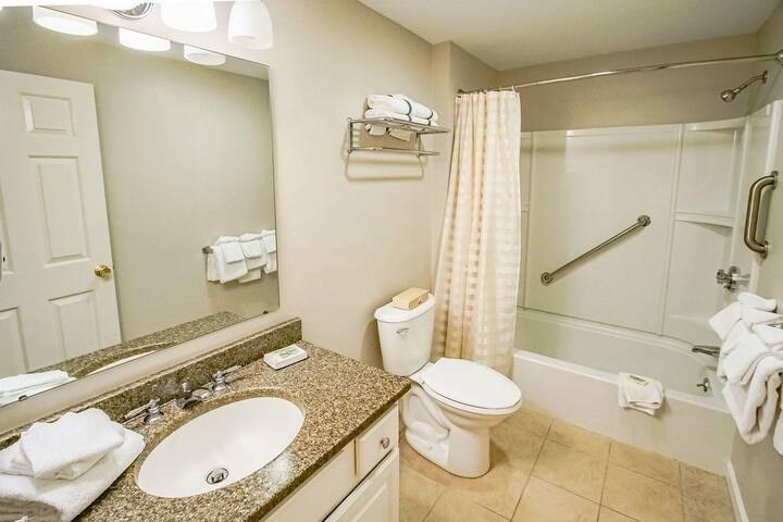 141 Great Neck Road South, Unit 203 Mashpee, MA 02649 - Photo 9 of 16 a bathroom with a granite countertop sink toilet and shower