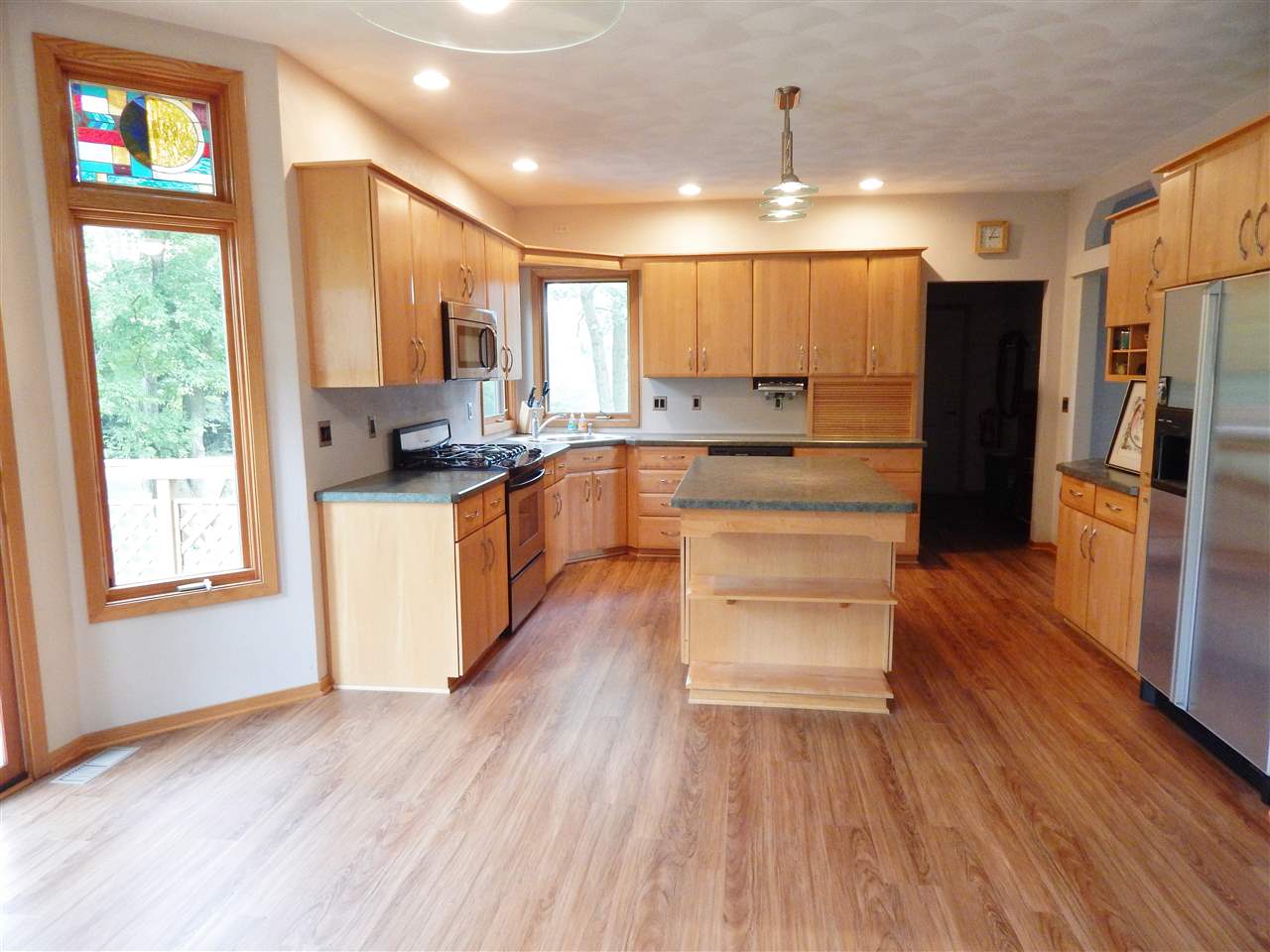 15673 Caledonia Road Caledonia, IL 61011 - Photo 8 of 25 a kitchen with a refrigerator and a stove top oven