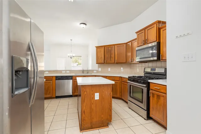 a kitchen with stainless steel appliances granite countertop a stove a sink dishwasher and a refrigerator