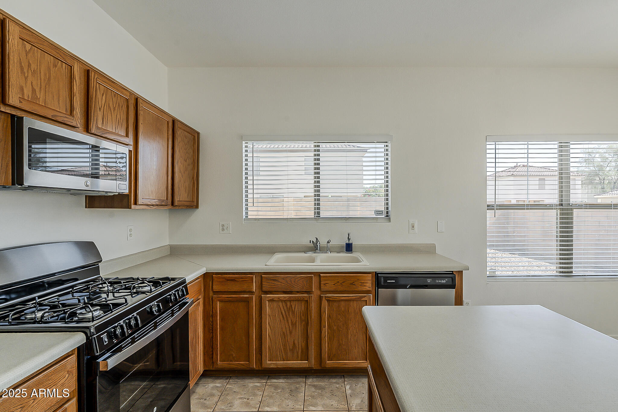 2286 East Peach Tree Drive Chandler, AZ 85249 - Photo 13 of 33 a kitchen with stainless steel appliances granite countertop a sink stove and cabinets