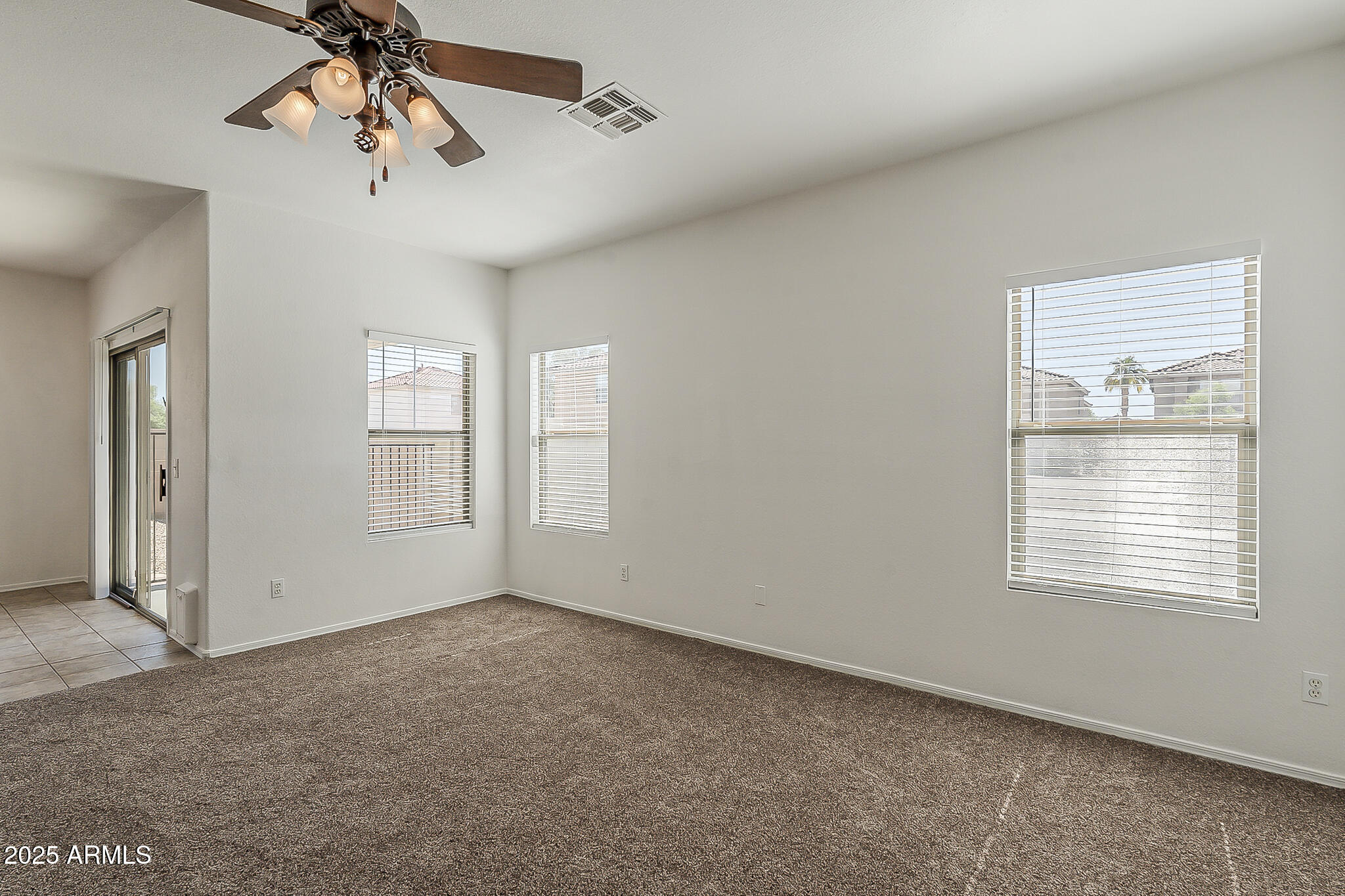 2286 East Peach Tree Drive Chandler, AZ 85249 - Photo 3 of 33 an empty room with windows and fan