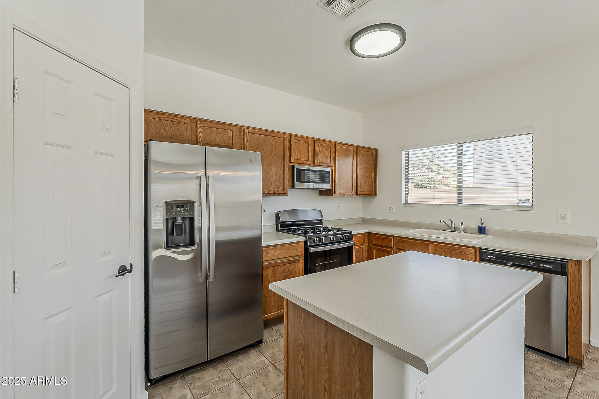 2286 East Peach Tree Drive Chandler, AZ 85249 - Photo 9 of 33 a kitchen with stainless steel appliances granite countertop a sink stove and refrigerator