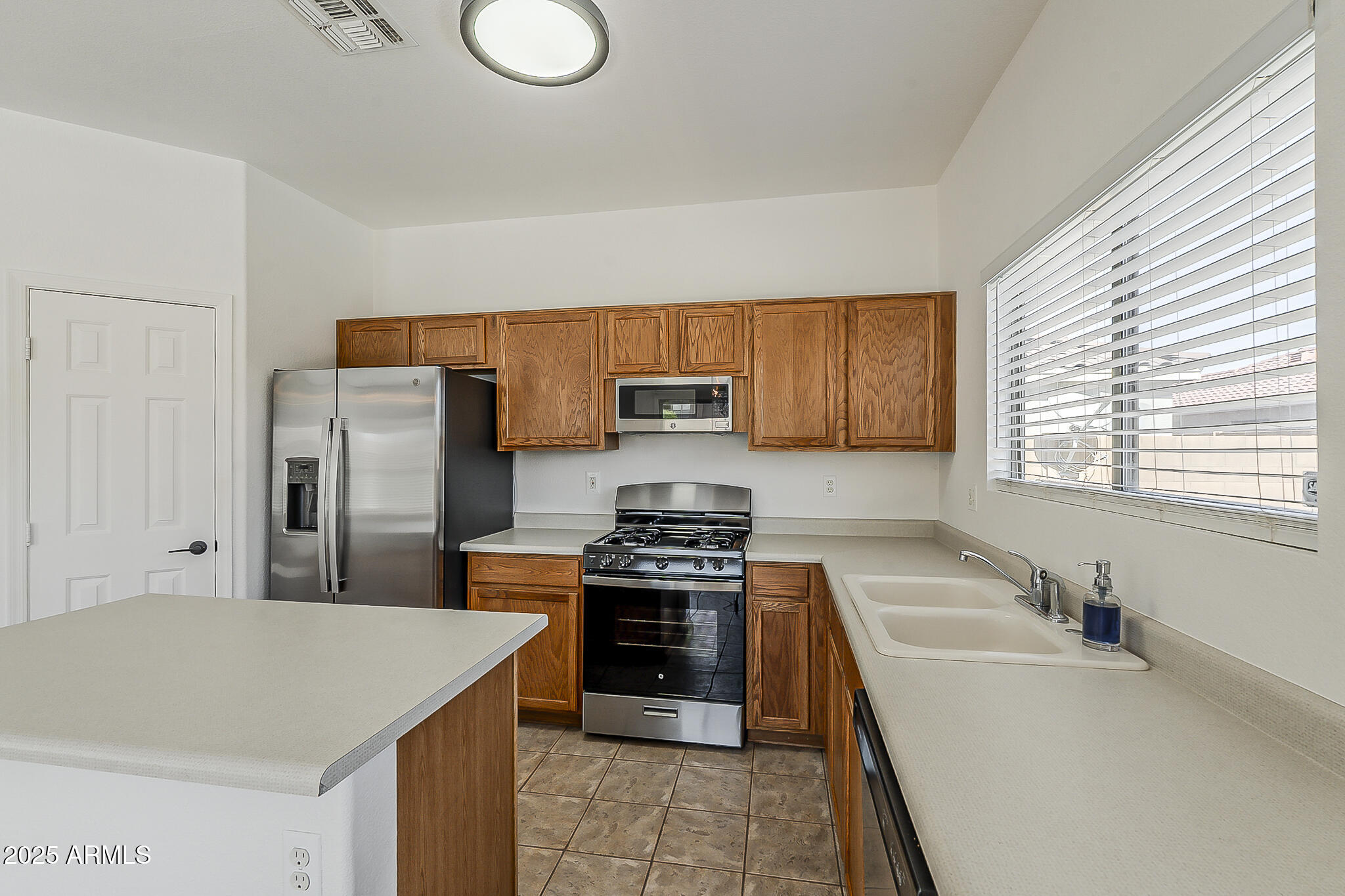 2286 East Peach Tree Drive Chandler, AZ 85249 - Photo 10 of 33 a kitchen with stainless steel appliances granite countertop a sink stove and refrigerator