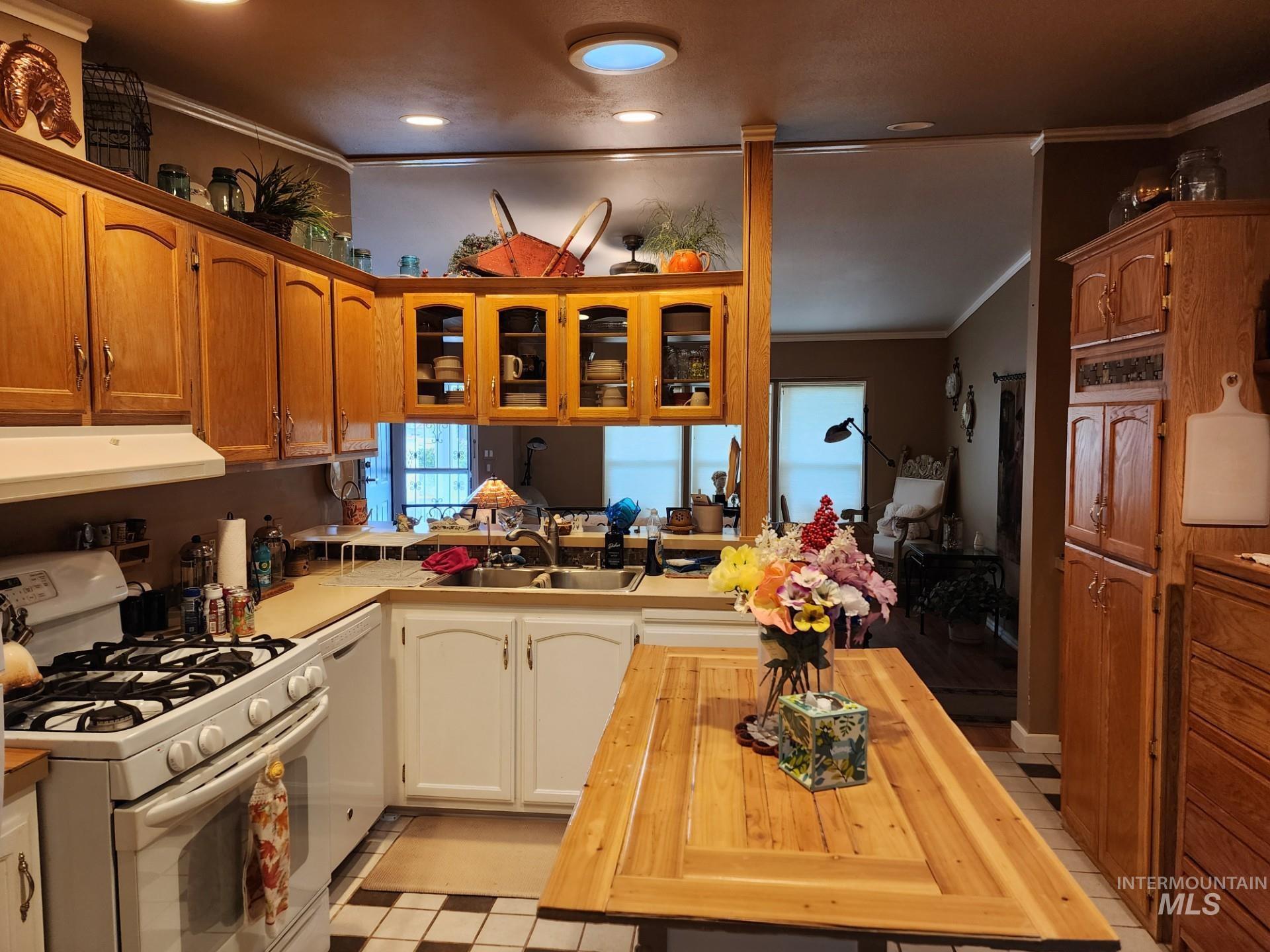 235 5th Street Grand View, ID 83624 - Photo 9 of 22 Kitchen featuring wood-finish cabinetry, white appliances, and a wood-finish island