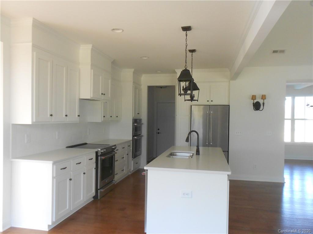 5606 Unionville-Brief Road Monroe, NC 28110 - Photo 12 of 21 a kitchen with stainless steel appliances kitchen island granite countertop a sink a refrigerator and white cabinets